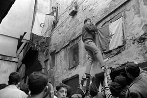 De jeunes Algériens aidés par des soldats de l’Armée de libération nationale (ALN) pavoisent les rues de la Casbah, à Alger, en juillet 1962. © Fernand Parizot/AFP