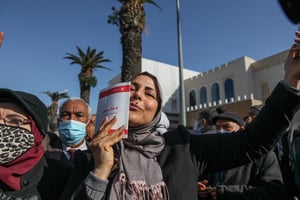 Une sympathisante d’Ennahdha embrassant la Constitution lors d’une manifestation contre la dissolution du Conseil supérieur de la magistrature, le 13 février 2022, à Tunis. © Chedly Ben Ibrahim/NurPhoto via AFP
