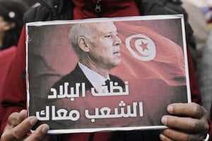 « Nettoie le pays, le peuple est avec toi », peut-on lire sur cette affiche brandie par un partisan du président Kaïs Saïed, lors du 11e anniversaire de la révolution à Tunis, le 17 décembre 2021. © Yassine Mahjoub/AFP