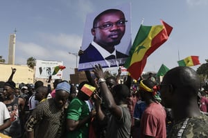 Des manifestants tiennent un drapeau du Sénégal et un portrait de l’opposant et maire de Ziguinchor, Ousmane Sonko, à Dakar, le 8 juin 2022. © SEYLLOU/AFP.