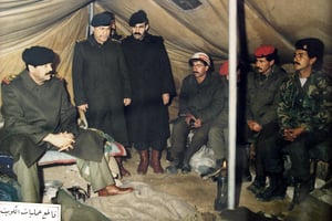 Saddam Hussein (assis, à g.) rendant visite à des troupes irakiennes dans un camp militaire au Koweït, après l’invasion de cet émirat, en août 1990. © Karim Sahib/AFP