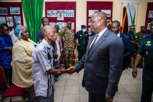 Le ministre de la Défense, Téné Birahima Ouattara, saluant Alfred Kouassi, le père d’un des militaires incarcérés au Mali, le 03 juillet 2022. © Sercom, ministère de la Défense – Ben Moumine Nikiema – DR.