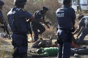Des policiers sud-africains autour des corps de mineurs tués lors de la grève, le 16 août 2012 à Marikana. © AP/SIPA