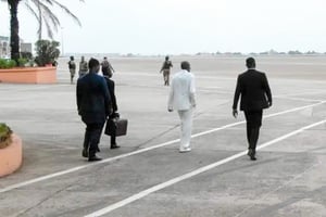 Alpha Condé (costume blanc) s’apprêtant à embarquer pour Istanbul, à Conakry, le 21 mai 2022. © Présidence de la République de Guinée