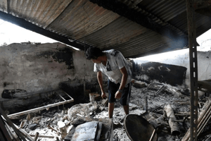Un habitant dans les décombres de sa maison détruite par un feu de forêt, le 18 août 2022 à El Kala, en Algérie. © AFP