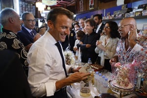 Emmanuel Macron visitant la boutique Disco Maghreb, à Oran, le 27 août 2022. À dr., Boualem Benhaoua, fondateur du célèbre label de raï. Au centre, Jack Lang, président de l’Institut du monde arabe (IMA). © (Photo by Ludovic MARIN / AFP)