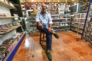 Boualem Benhaoua dans sa boutique et siège du label Disco Maghreb, à Oran, le 24 juillet 2022. © RYAD KRAMDI/AFP