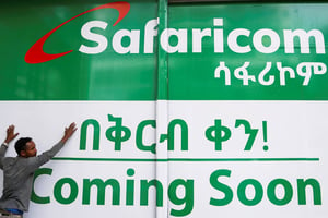 Un employé fixe une publicité sur la devanture d’une boutique Safaricom Ethiopia à Addis-Abeba, le 29 juillet 2022. © REUTERS/Tiksa Negeri
