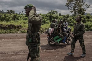 Un motocycliste transporte des soldats tandis que d’autres patrouillent dans la zone de Kibumba qui a été attaquée par des rebelles du M23 lors d’affrontements avec l’armée congolaise, près de la ville de Goma, dans l’est de la RDC, le 1er juin 2022. © Photo by Guerchom Ndebo / AFP
