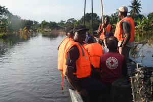 Des responsables de la Croix-Rouge et de l’Agence nationale de gestion des urgences se portent au secours des résidents déplacés de la communauté d’Ula-Ikata submergée par les inondations dans le district d’Ahoada de l’État de Rivers, au Nigeria, le 22 octobre 2022. © (Photo by PIUS UTOMI EKPEI / AFP)