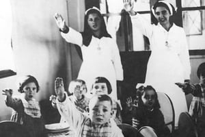 Deux assistantes sociales faisant faire le salut fasciste à des enfants, en Galicie (Espagne), en 1937. © Efe / Sipa