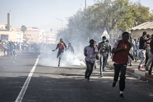 Manifestation à Dakar, le 8 mars 2021, après que le chef de l’opposition, Ousmane Sonko, a été accusé de viol. A protester jumps over a teargas canister during a protest in Dakar on March 8, 2021, after the country’s opposition leader Ousmane Sonko was charged with rape. – Usually considered a beacon of stability in a volatile region, deadly clashes between opposition supporters and security forces have rocked the West African state. 
© JOHN WESSELS/AFP