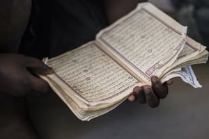 Un homme tenant un Coran entre ses mains. © Sylvain Cherkaoui pour JA