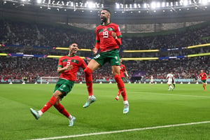 L’attaquant marocain Youssef En-Nesyri et le défenseur Achraf Hakimi exultent après le premier but lors du quart de finale de la Coupe du monde Qatar 2022 entre le Maroc et le Portugal à Doha le 10 décembre 2022. © (Photo by PATRICIA DE MELO MOREIRA / AFP)