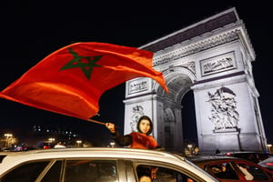 Des supporters marocains célèbrent la victoire de leur équipe en quart de finale de la Coupe du monde 2022 face à l’Espagne, le 6 décembre 2022, à Paris sur les Champs Élysées. © JULIEN MATTIA/Anadolu Agency via AFP.
