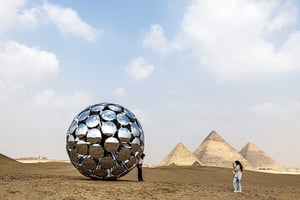 Touristes posant devant une installation de l’artiste SpY sur le site de Gizeh, en Égypte, le 22 octobre 2022. © Khaled Desouki/AFP