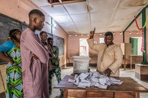 Des membres de la commission électorale (Cena) vérifient le décompte des bulletins de vote après les élections législatives du 8 janvier 2023, à l’école Charles-Guillot de Zongo à Cotonou. © Yanick Folly / AFP