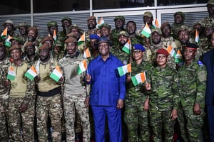 Alassane Ouattara, avec les 46 militaires ivoiriens, le 7 janvier à l’aéroport d’Abidjan. © SIA KAMBOU/AFP
