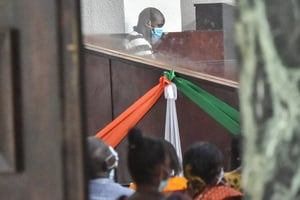 Amadé Ouérémi (au centre, en haut), un ancien chef de guerre accusé de massacres dans l’ouest de la Côte d’Ivoire en 2011, attendant le début de son procès au tribunal de grande instance d’Abidjan, le 1er avril 2021. © Photo by SIA KAMBOU / AFP
