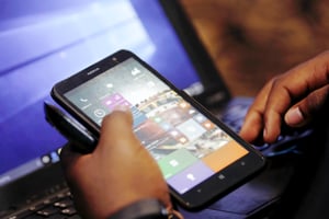 Un délégué de Microsoft vérifie les applications sur un smartphone lors du lancement du système d’exploitation Windows 10 à Nairobi, au Kenya. © Thomas Mukoya/REUTERS