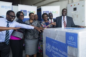Charles Njuguna (D), directeur en charge des incidents du Bureau national de l’OMS en Ouganda, et la ministre ougandaise de la Santé, Jane Ruth Aceng (3e D), à la réeption de 1 200 doses de vaccin contre Ebola, à Entebbe le 8 décembre 2022. © Badru Katumba/AFP
