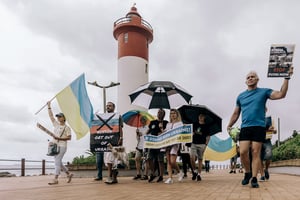 Des manifestants de l’Association ukrainienne d’Afrique du Sud protestent, le 18 février 2023 sur la plage d’Umhlanga, à Durban, contre l’exercice militaire conjoint de cette dernière avec la Russie et la Chine. © Photo by RAJESH JANTILAL / AFP