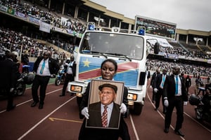 Une femme tient le portrait de l’ancien Premier ministre et chef de l’opposition de la RDC, Étienne Tshisekedi, alors que sa dépouille arrive à la cérémonie de deuil au stade des Martyrs de la Pentecôte à Kinshasa, le 31 mai 2019. © John WESSELS / AFP