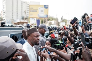 L’opposant Ousmane Sonko s’adresse aux journalistes alors que son convoi est arrêté sur la route vers son procès, à Dakar le 16 mars 2023. © GUY PETERSON / AFP