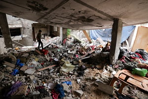 Un Palestinien dans sa maison détruite dans la ville de Gaza,touchée lors de la dernière série de combats entre les militants de Gaza et l’armée israélienne, le 13 juin 2023. © MAHMUD HAMS / AFP