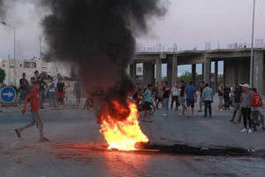 Des jeunes tunisiens bloquent la route des migrants, le 4 juillet 2023, alors que les tensions montent à Sfax après l’enterrement d’un jeune Tunisien poignardé à mort lors d’une bagarre entre des habitants et des africains subsahariens. © HOUSSEM ZOUARI/AFP