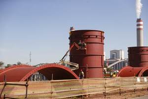 Des travailleurs d’Eskom installent des cheminées temporaires à la centrale électrique de Kusile, une centrale au charbon située sur la ferme de Hartbeesfontein à Emalahleni, le 22 mai 2023. © Phill Magakoe / AFP