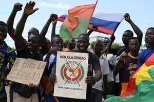 Un petit groupe de manifestants brandit des drapeaux de la Russie et du Burkina alors qu’ils protestent contre la Communauté économique des États de l’Afrique de l’Ouest à Ouagadougou, le 4 octobre 2022. © Issouf SANOGO/AFP