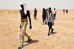 Migrants subsahariens, près de la zone désertique d’Al-Assah, à la frontière tuniso-libyenne, le 30 juillet, 2023. © Mahmud Turkia/AFP