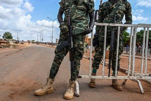 Des soldats de la police nigérienne montent la garde devant les bases aériennes nigérienne et française à Niamey alors que les partisans du CNSP se rassemblent le 27 août 2023. © AFP