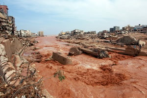 Des personnes observent les dégâts causés par les inondations à Derna, le 11 septembre 2023. © AFP