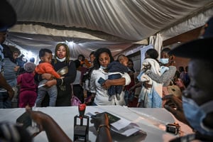 Des Ivoiriennes et leurs enfants rapatriés de Tunisie passent les formalités de police après leur arrivée à l’aéroport Félix-Houphouët-Boigny d’Abidjan, le 04 mars 2023. © Sia KAMBOU / AFP