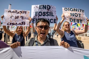 Des militants brandissent des pancartes lors d’une manifestation contre la pauvreté et le changement climatique, le premier jour des réunions annuelles du FMI et de la BM, à Marrakech, le 9 octobre 2023. © FADEL SENNA / AFP