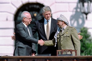 Le président américain Bill Clinton entre le chef de l’OLP Yasser Arafat et le Premier ministre israélien Yitzahk Rabin qui se serrent la main pour la première fois, le 13 septembre 1993 à la Maison Blanche. © J. DAVID AKE / AFP