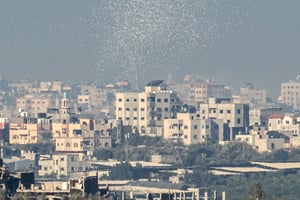 Une photo prise à la frontière entre Israël et Gaza montre des tracts largués par l’armée israélienne au-dessus de la ville de Gaza, demandant aux habitants d’évacuer la zone, le 16 novembre 2023. © JACK GUEZ / AFP