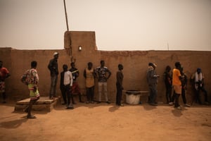 Des migrants non enregistrés attendent devant le centre d’information de l’Organisation internationale pour les migrations (OIM), à Arlit, au Niger, le 29 mars 2023. © STANISLAS POYET / AFP