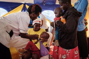 Un enfant kényan reçoit une dose du vaccin RTS,S contre le paludisme, dans le dispensaire de Gisambai, en mars 2023. © YASUYOSHI CHIBA / AFP