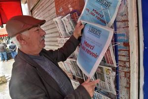 Un vendeur de journaux accroche le dernier numéro du quotidien algérien francophone « Liberté » dans un kiosque à Alger, le 14 avril 2022. © RYAD KRAMDI / AFP