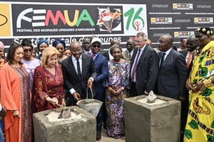 Salif Traore, dit A’Salfo, du groupe Magic System, et la première dame de Côte d’Ivoire Dominique Ouattara posent la première pierre de deux écoles primaires à San-Pedro et Jacqueville, lors de l’ouverture du FEMUA à Abidjan, le 14 mai 2024. © Sia KAMBOU / AFP