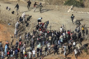 Des migrants tentent de franchir la frontière terrestre avec l’enclave africaine espagnole de Ceuta, près de Fnideq, dans le nord du Maroc, le 15 septembre 2024. © AFP