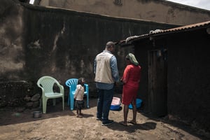 Un membre de la fondation Bridgeway parle avec une femme ayant réussi à échapper à l’ADF, à Kasindi situé dans l’est de la RDC. © ALEXIS HUGUET / AFP