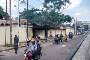 Des personnes passent devant de l’ambassade de France, attaquée lors de la manifestation, à Kinshasa, du 28 janvier 2025. © Hardy BOPE / AFP