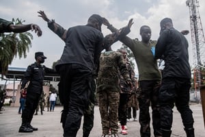 Des soldats des FDLR sont fouillés par un fonctionnaire rwandais au principal poste frontière entre la RDC et le Rwanda, à Goma, lors de leur rapatriement au Rwanda par le M23, le 1er mars 2025. © Jospin Mwisha / AFP