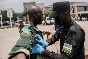 Des soldats des Forces démocratiques de libération du Rwanda (FDLR) sont fouillés par un fonctionnaire rwandais au principal poste frontière entre la RD Congo et le Rwanda, à Goma, le 1er mars 2025. © Jospin Mwisha / AFP