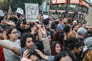 Un jeune homme tunisien brandit une pancarte sur laquelle on peut lire en arabe « un système au bord de l’effondrement », lors d’une manifestation organisée à Tunis, le 15 avril 2025. © Chedly Ben Ibrahim / NurPhoto / NurPhoto via AFP