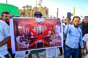Un manifestant marche avec une pancarte hostile au Premier ministre du gouvernement d’unité nationale, Abdulhamid Dbeibah, place des Martyrs à Tripoli le 23 mai 2025. © AFP